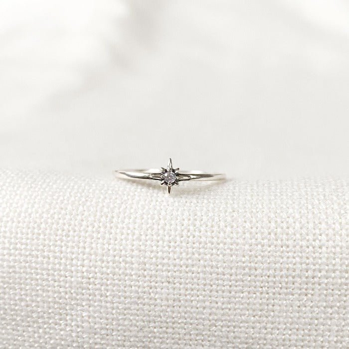 Bague minimaliste en Argent Sterling 925 avec une étoile pleine au centre, ornée d'un zircon lumineux, portée sur le majeur en combinaison avec d'autres bagues pour un look raffiné.