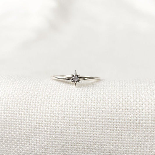 Bague minimaliste en Argent Sterling 925 avec une étoile pleine au centre, ornée d'un zircon lumineux, portée sur le majeur en combinaison avec d'autres bagues pour un look raffiné.