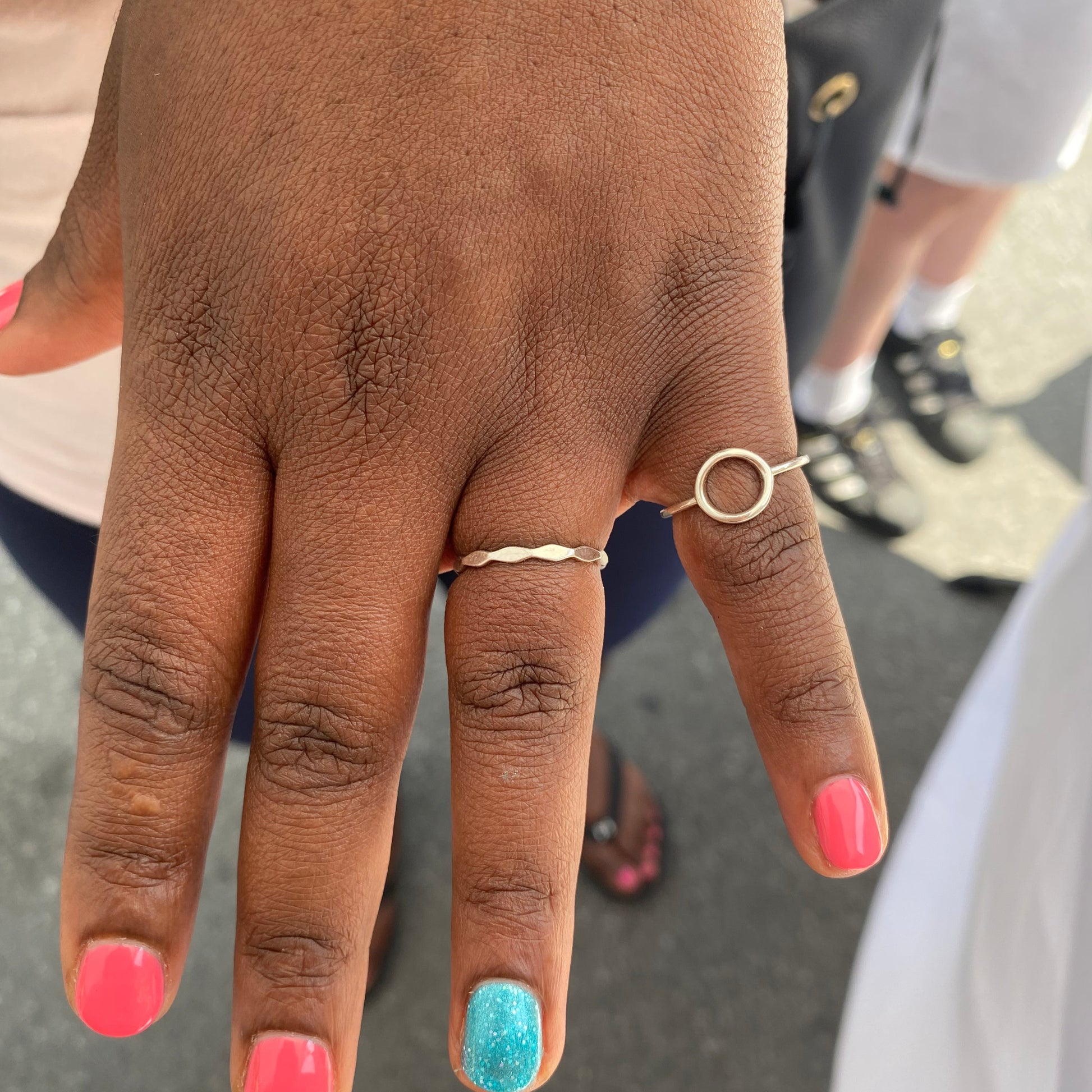 Bague Onde en Argent Sterling portée par une cliente sur l'annulaire en combinaison avec la bague Cercle, créant un look élégant et délicat, mettant en valeur la fluidité du design ondulé.