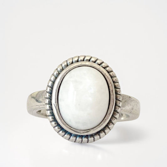 Bague en argent sterling 925 "Moonstone" sertie d'une pierre de lune arc-en-ciel ovale aux reflets bleus et argentés. Élégante et intemporelle, elle capte la lumière avec mystère. Photo de face sur fond blanc.