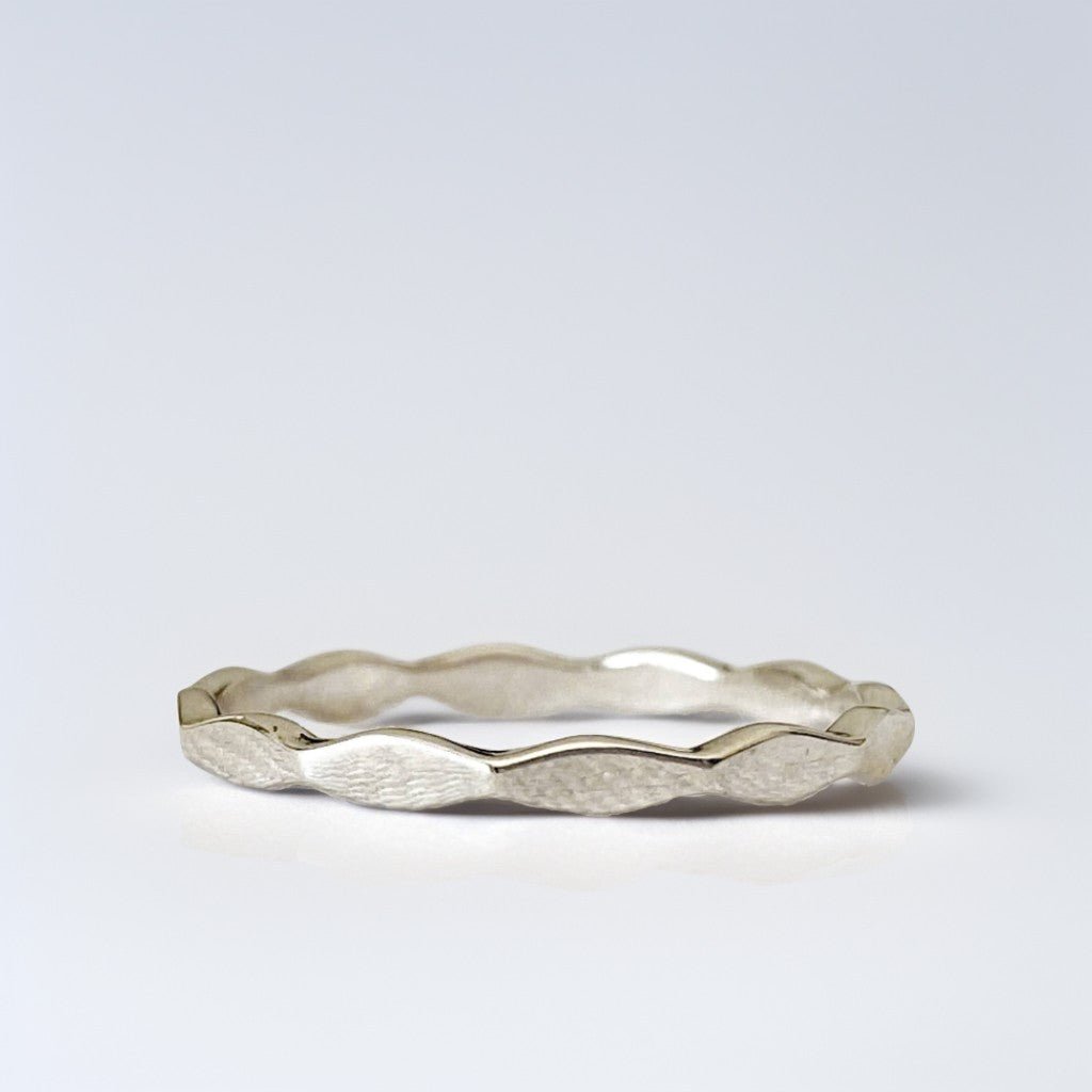 Bague en argent sterling 925 "Onde" avec anneau ondulé au design minimaliste et élégant. Inspirée des courbes naturelles, elle évoque fluidité et harmonie. Photo de face sur fond blanc.