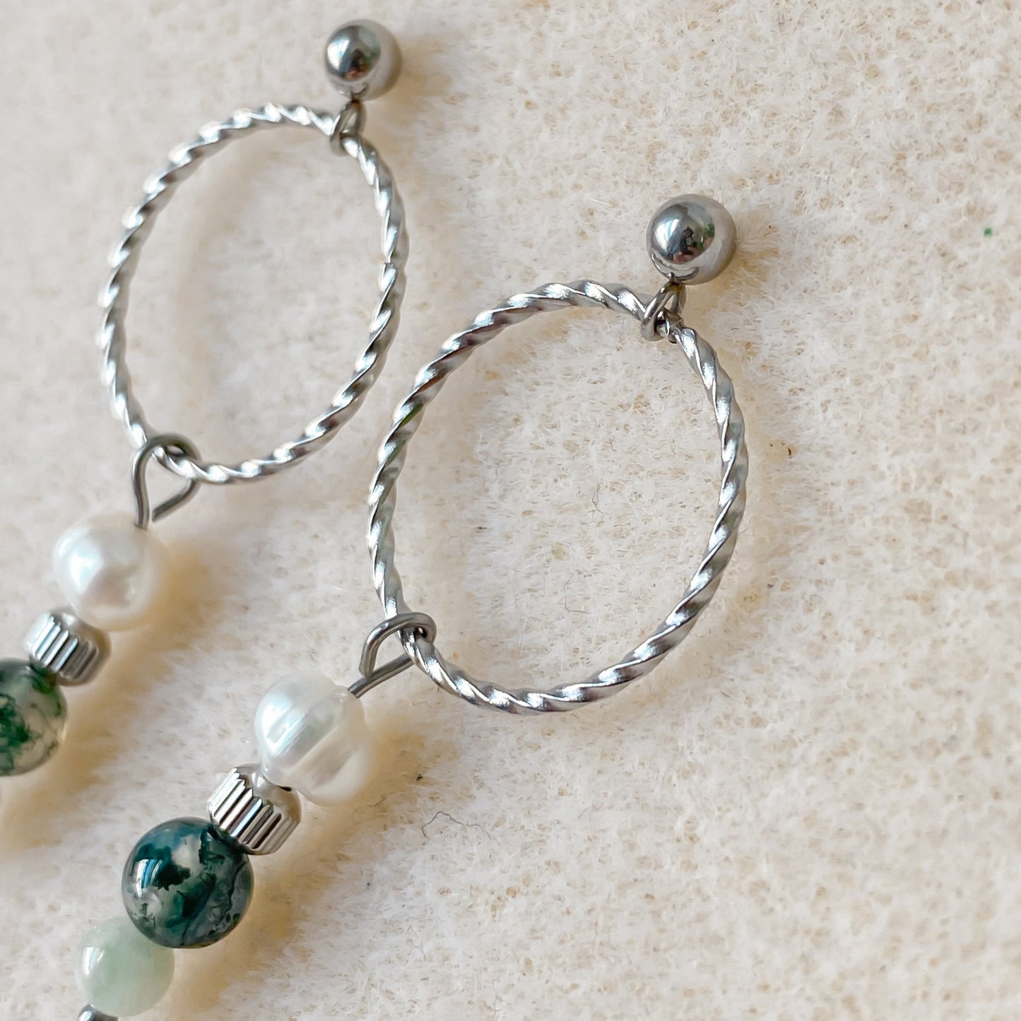 Vue latérale des boucles Chloris avec anneau torsadé, pierres naturelles et perle d’eau douce.
