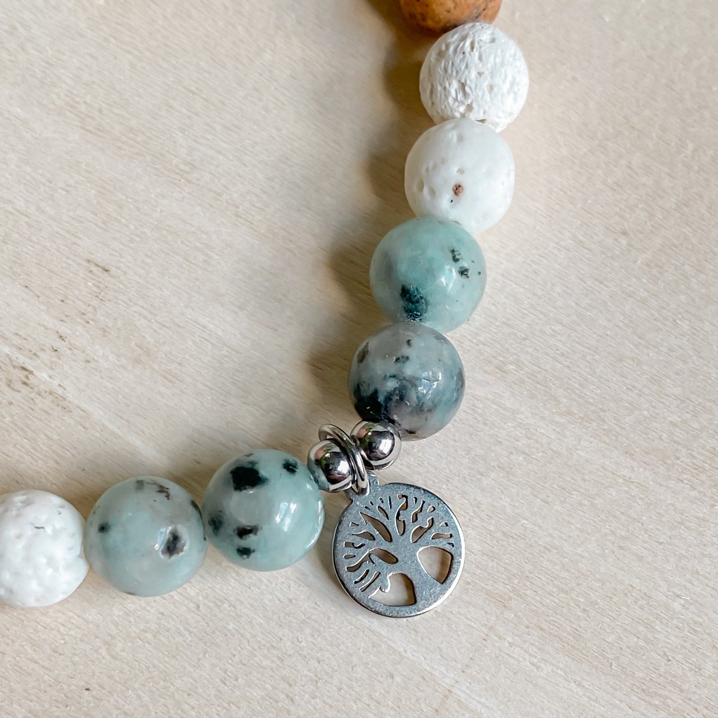 Détail du pendentif arbre de vie argenté sur bracelet en jaspe kiwi, jaspe paysage et pierre de lave blanche.