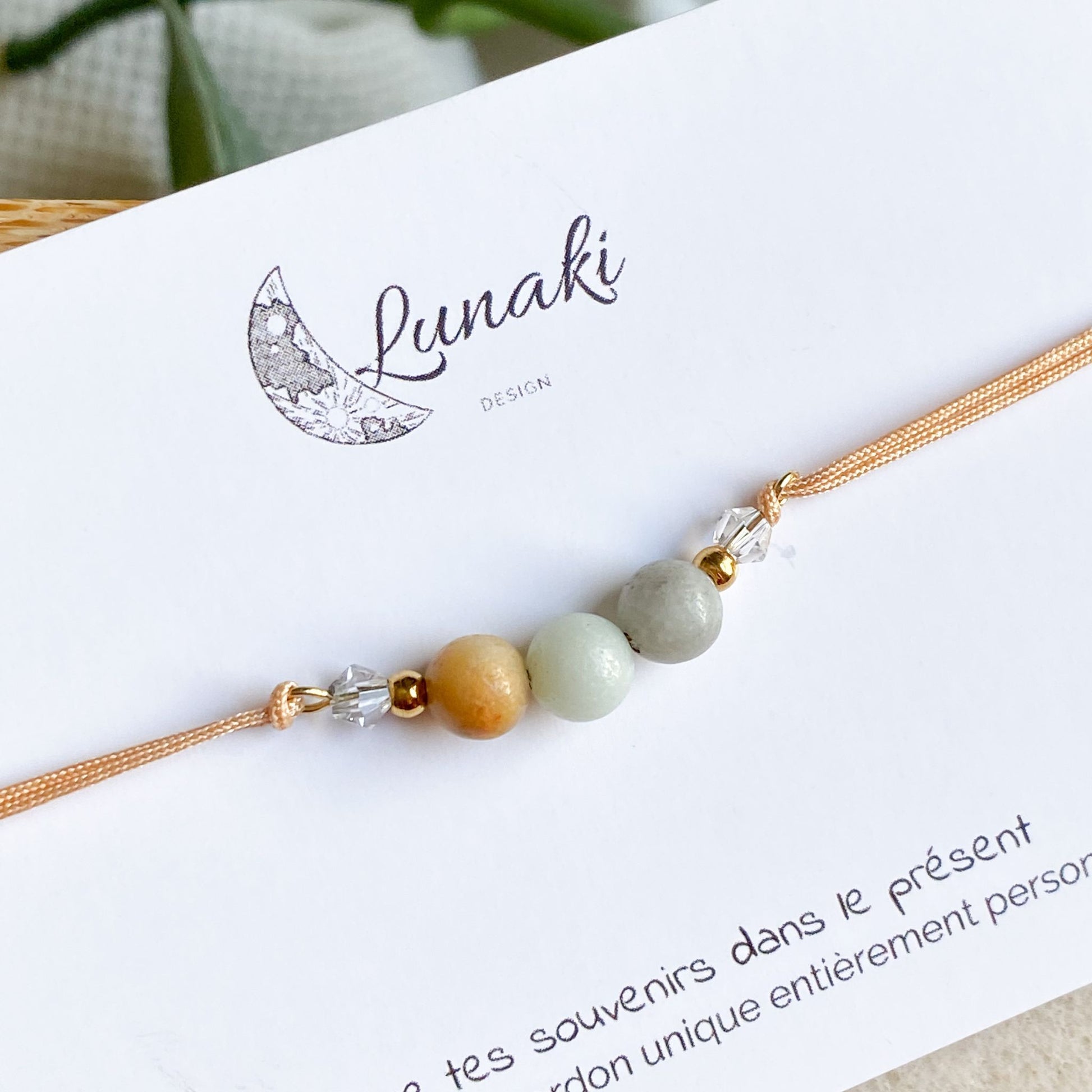 Gros plan du bracelet cordon personnalisable Gardien des Souvenirs en acier doré, montrant les détails des pierres et des billes en acier inoxydable.