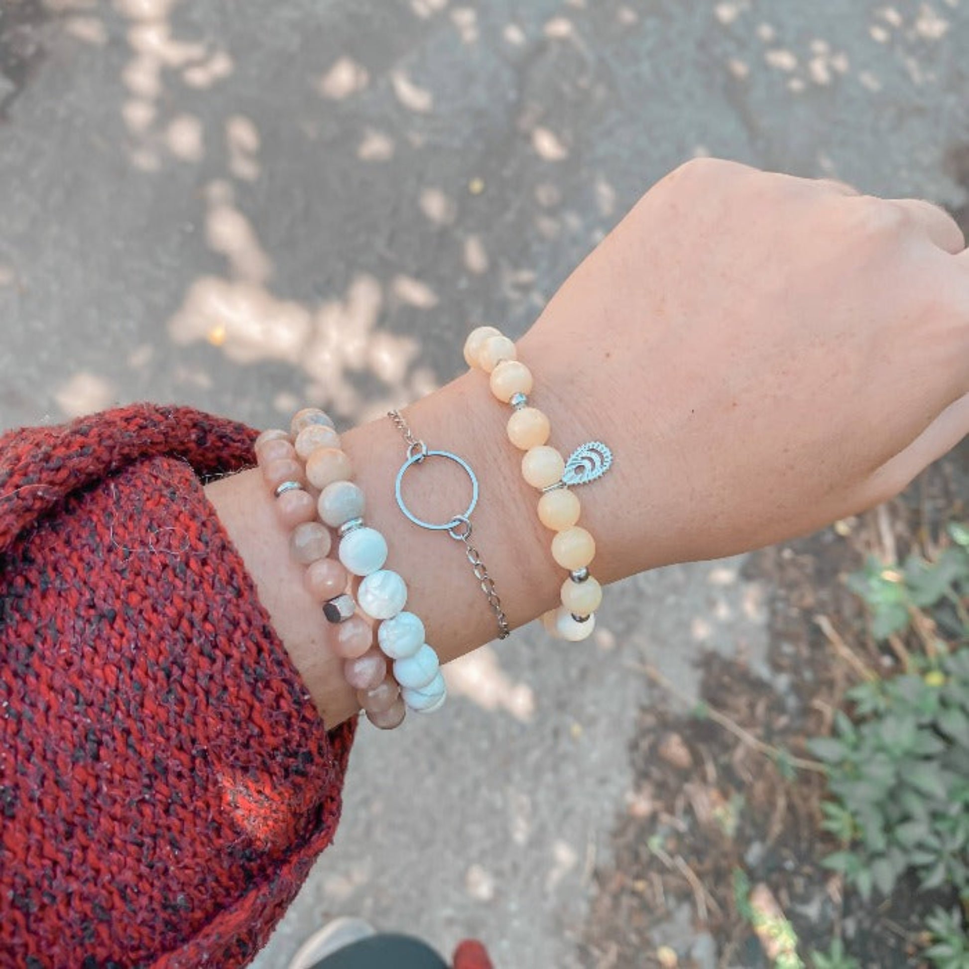 Bracelet minimaliste en chaîne fine Cernes porté au poignet, combiné avec des bracelets en pierres naturelles pour un look élégant et moderne.