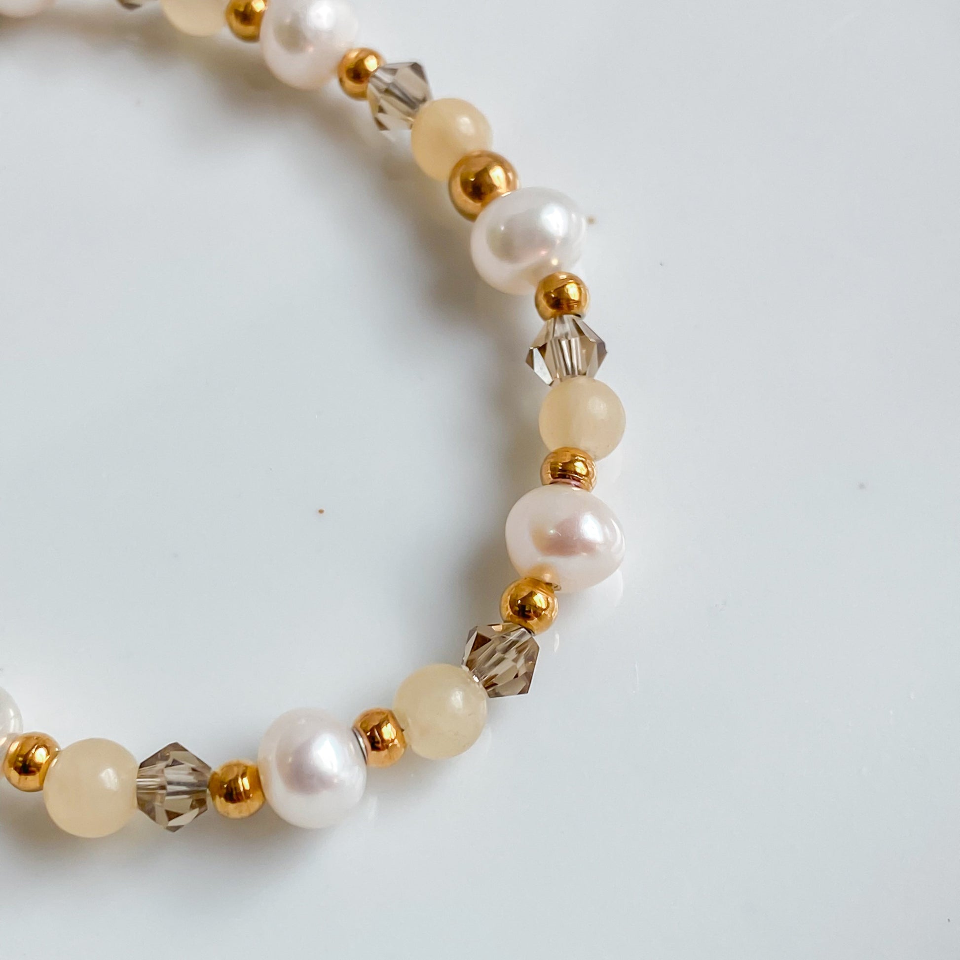 Bracelet doré Théia composé de jade jaune, perles d’eau douce et cristaux fumés, création artisanale Lunaki.