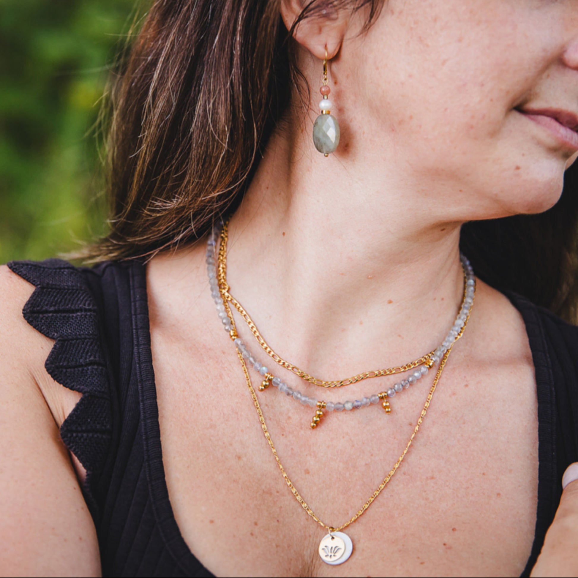 Collier Aurora en acier inoxydable doré 18K porté avec un collier de labradorite et un pendentif rond, superposition tendance.