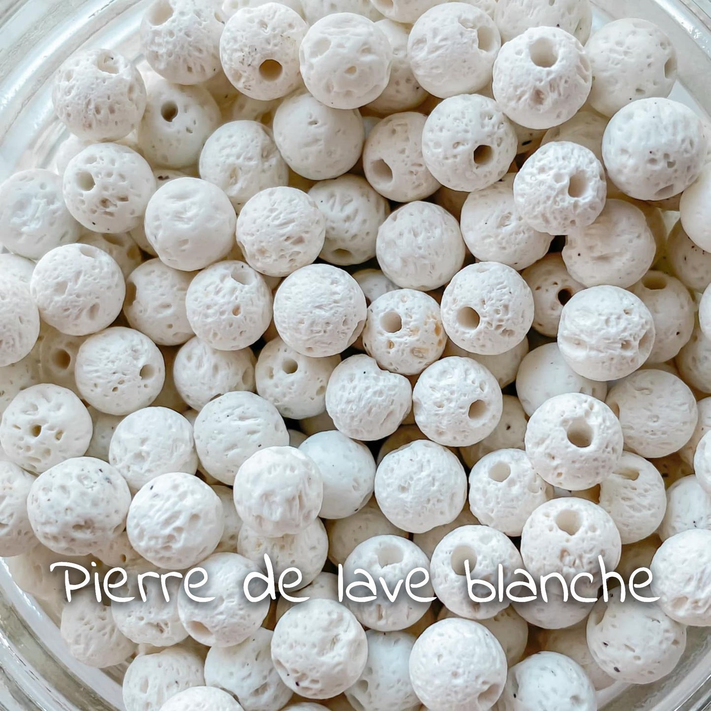 Gros plan sur la pierre de lave blanche, montrant sa texture poreuse et ses nuances claires.