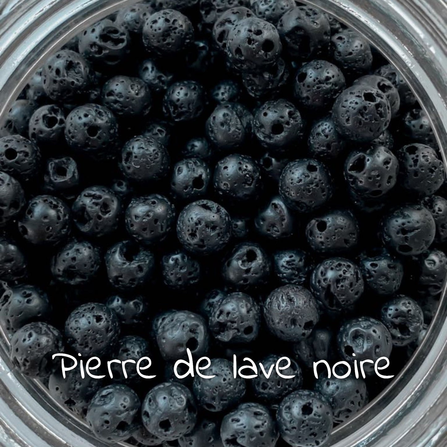 Gros plan sur la pierre de lave noire, illustrant sa texture rugueuse et son aspect sombre.