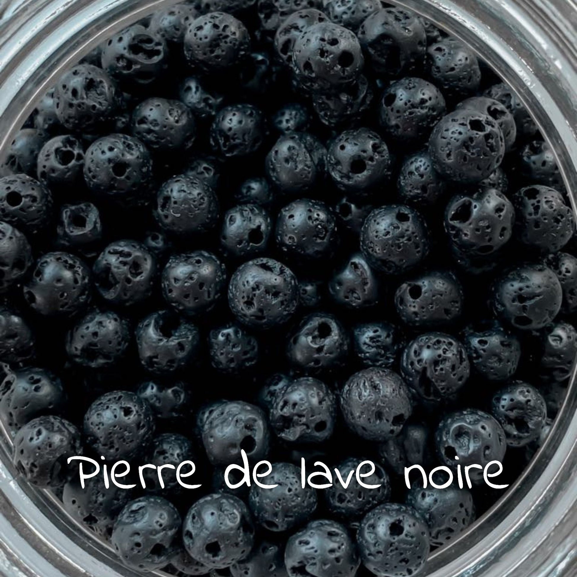 Gros plan sur la pierre de lave noire, illustrant sa texture rugueuse et son aspect sombre.