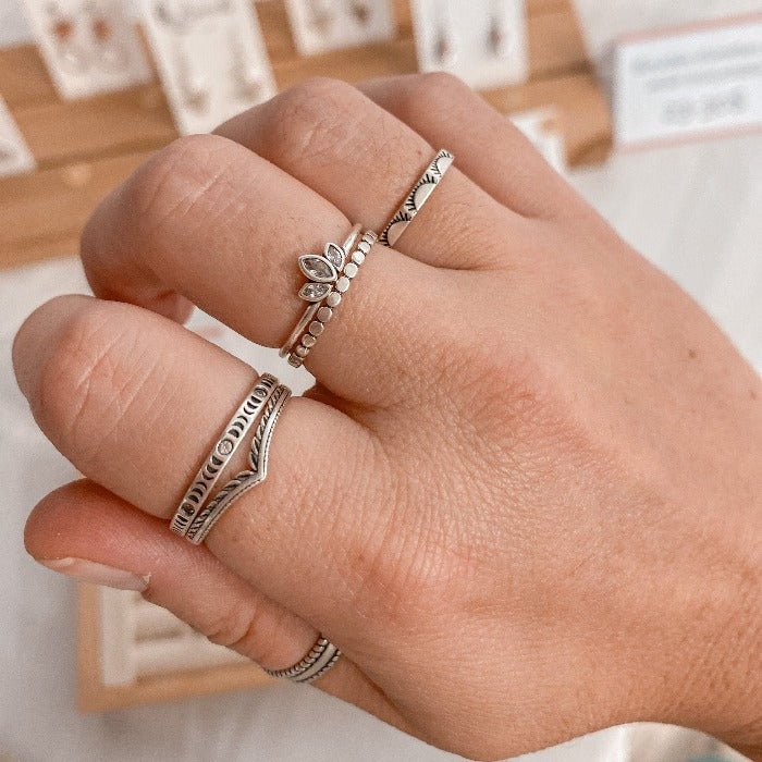 Bague Lotus en Argent Sterling 925 portée avec les bagues Pico, Sunny, Moonphase, Eden et Jonc, formant une combinaison élégante et créative, mettant en avant la fleur de lotus en relief et les zircons dans un ensemble sophistiqué.