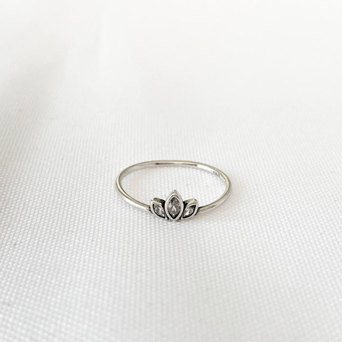 Bague Lotus en Argent Sterling 925 vue de haut sur fond blanc, mettant en valeur la fleur de lotus en relief au centre, accompagnée de trois zircons, pour un design délicat et raffiné.