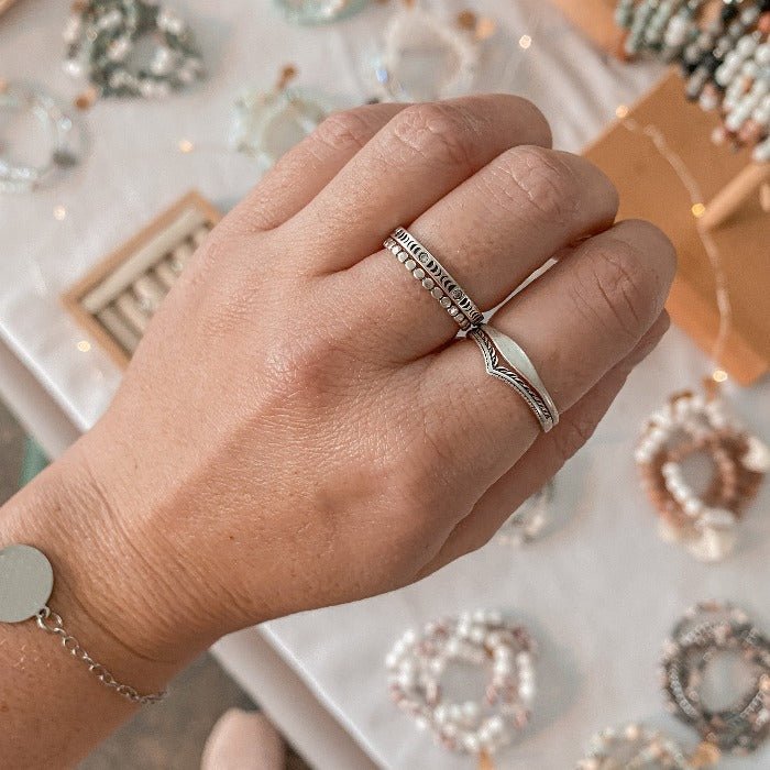 Bague Moonphase en Argent Sterling 925 portée sur le majeur en combinaison avec les bagues Pico, Flow et Eden, mettant en valeur les phases lunaires en relief et les zircons, pour un look élégant et mystique.