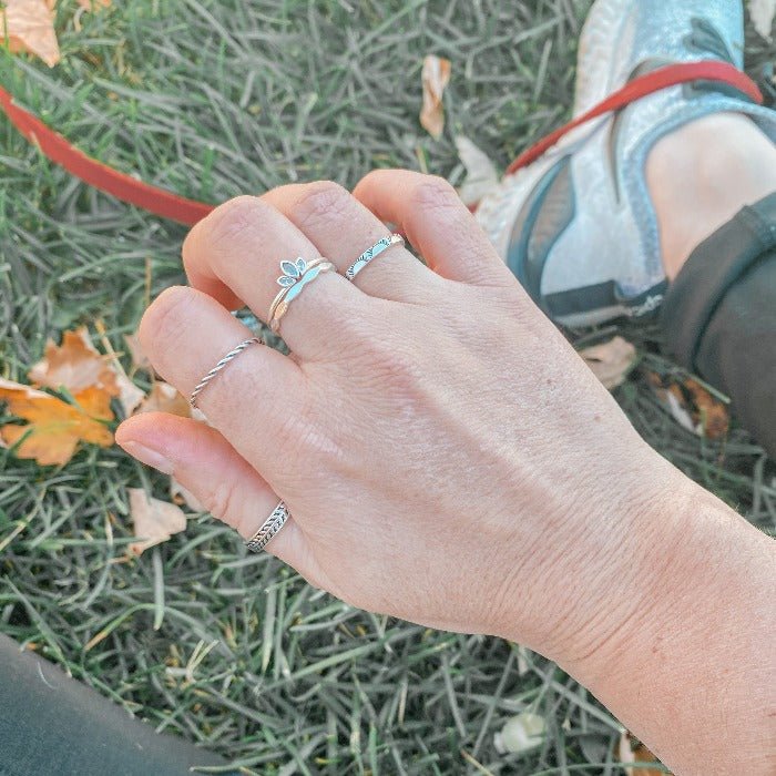 Bague Onde en Argent Sterling portée avec les bagues Lotus, Sunny, Torsade et Spring, créant une combinaison élégante et raffinée, idéale pour un look sophistiqué et bohème.