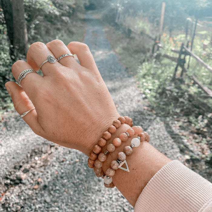 Bague Flow en argent sterling 925 portée en combinaison avec les bagues Gypsie, Sunny, Eden, Pico et Aube sur fond de forêt, créant un look naturel et élégant, parfait pour un style boho-chic.