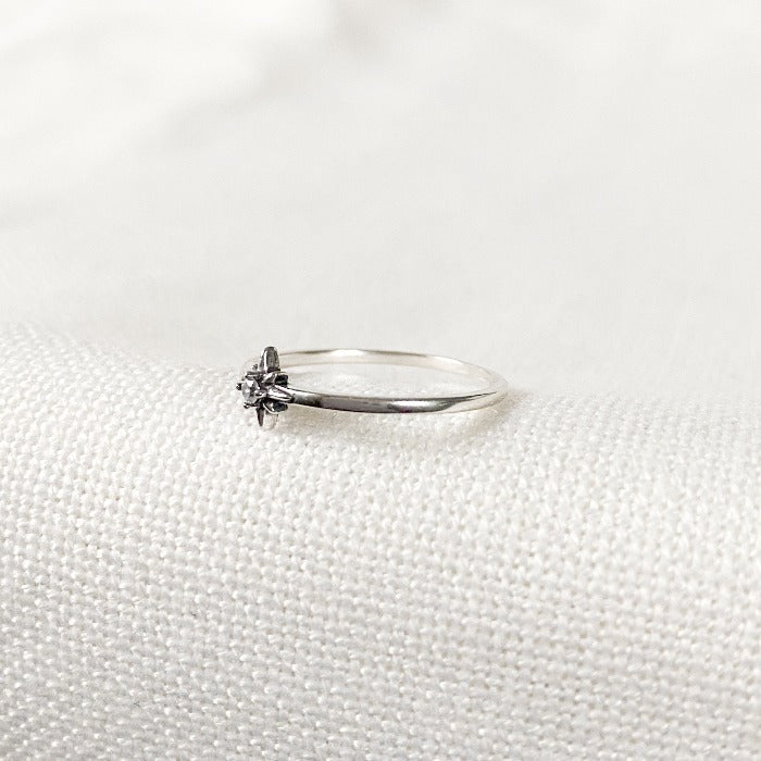 Bague Estrella en Argent Sterling 925 vue de côté, mettant en valeur l'étoile centrale et le zircon lumineux, sur un fond blanc minimaliste.