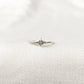 Bague minimaliste en Argent Sterling 925 avec une étoile pleine au centre, ornée d'un zircon lumineux, portée sur le majeur en combinaison avec d'autres bagues pour un look raffiné.