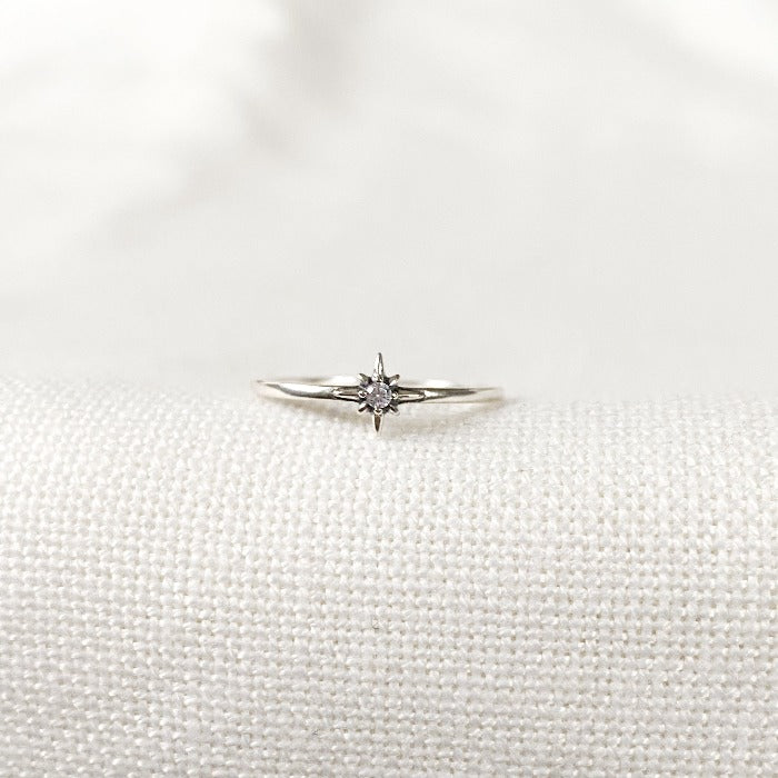 Bague minimaliste en Argent Sterling 925 avec une étoile pleine au centre, ornée d'un zircon lumineux, portée sur le majeur en combinaison avec d'autres bagues pour un look raffiné.