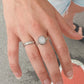 Bague Moonstone en Argent Sterling 925 portée sur le majeur en combinaison avec une bague jonc, mettant en avant la pierre de lune arc-en-ciel et créant un look élégant et harmonieux.
