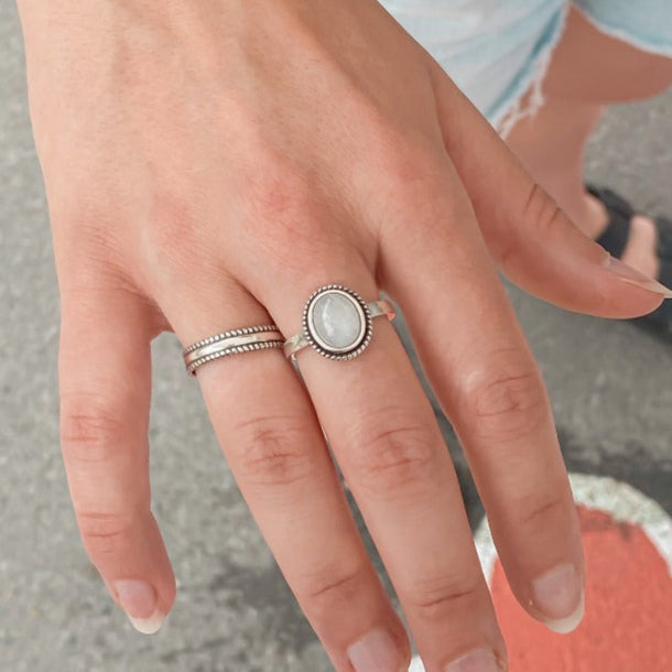Bague Moonstone en Argent Sterling 925 portée sur le majeur en combinaison avec une bague jonc, mettant en avant la pierre de lune arc-en-ciel et créant un look élégant et harmonieux.