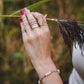 Bague Calypso dorée en nacre portée à la main avec bracelet pierres naturelles