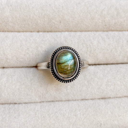 Gros plan sur la bague Morgane en argent 925 sertie d’une labradorite ovale, nuances lumineuses uniques.