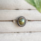 Bague Morgane en argent sterling 925 et labradorite naturelle posée sur un présentoir clair, reflets verts et dorés.
