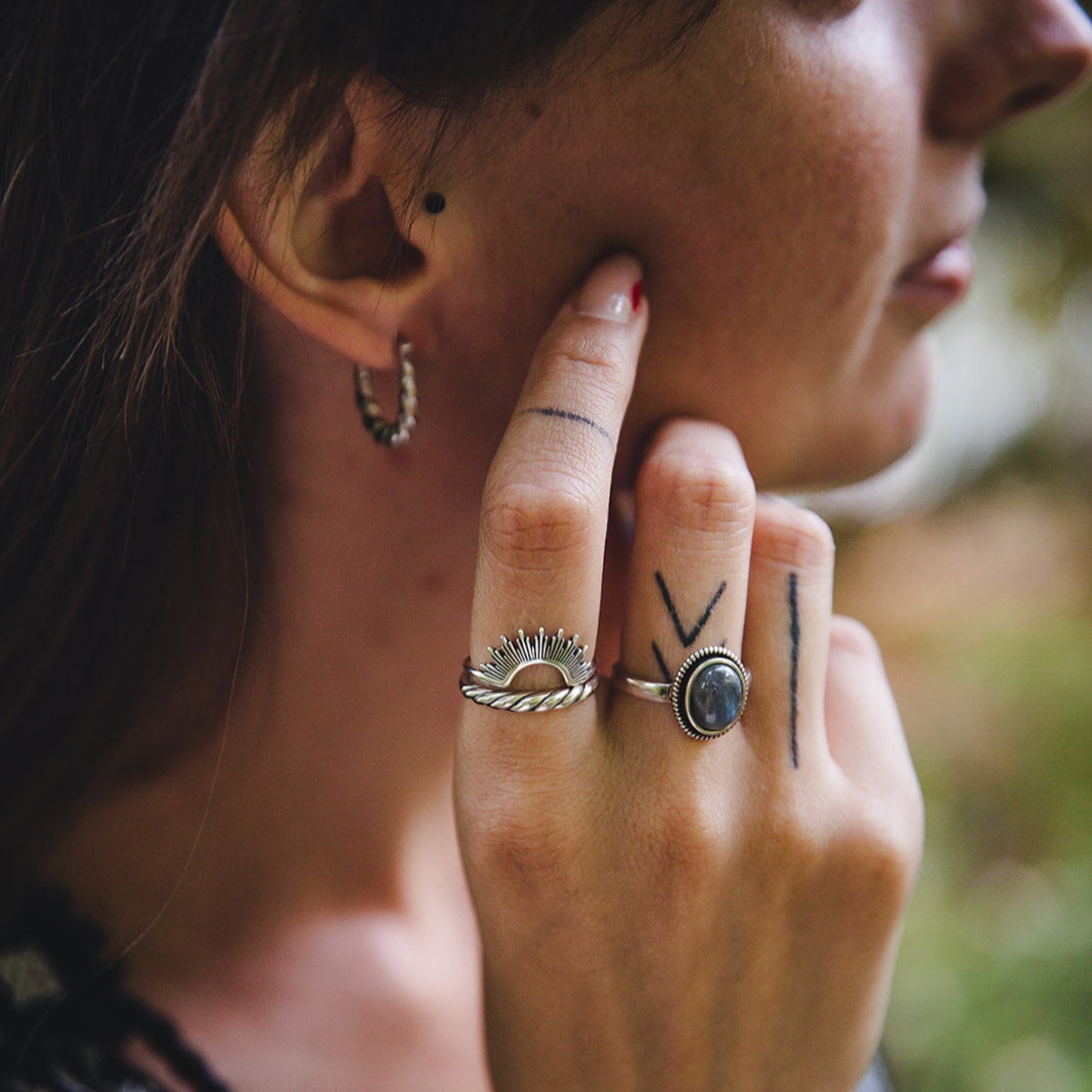 Main féminine ornée de la bague Morgane en argent 925 avec cabochon de labradorite, look bohème.
