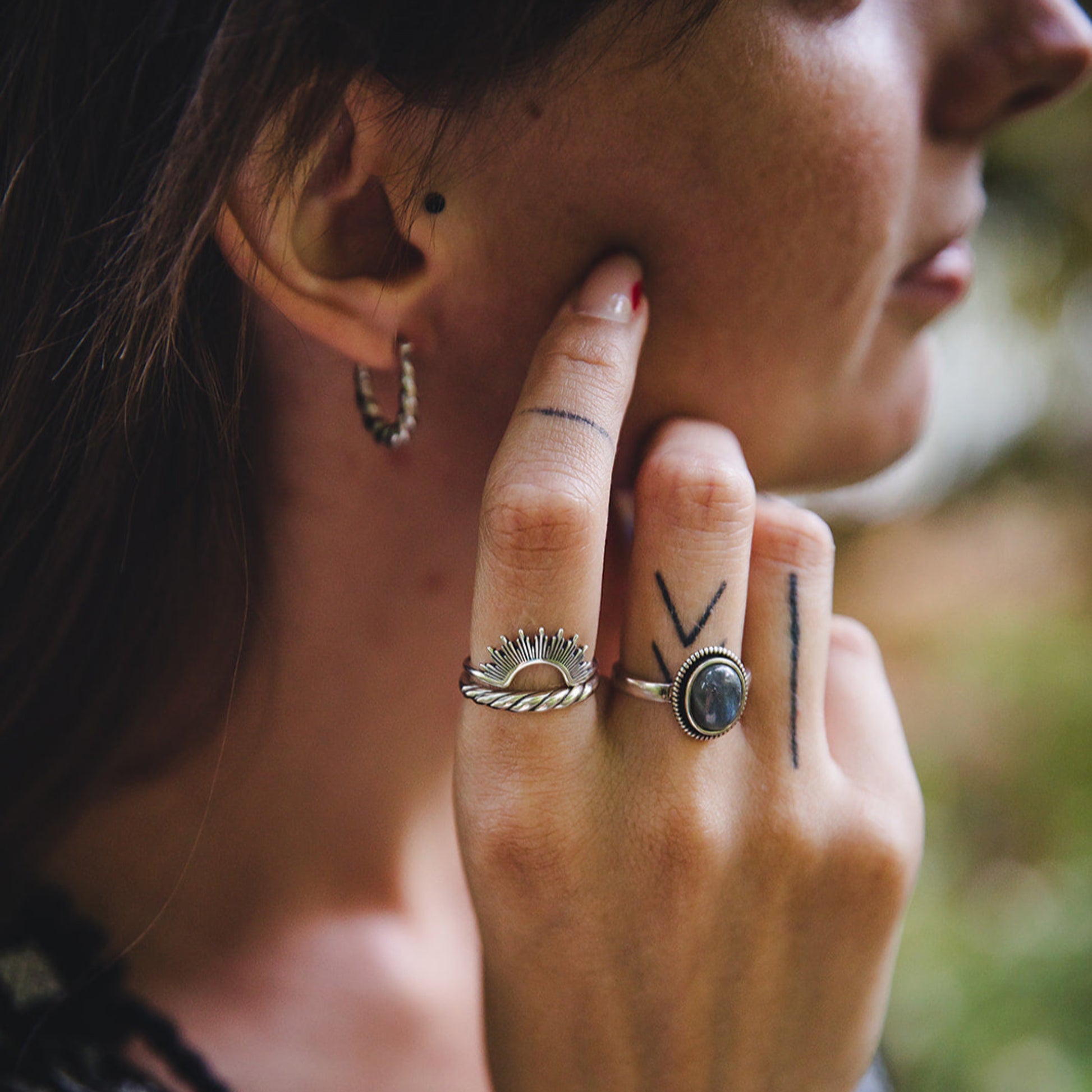 Main féminine ornée de la bague Morgane en argent 925 avec cabochon de labradorite, look bohème.
