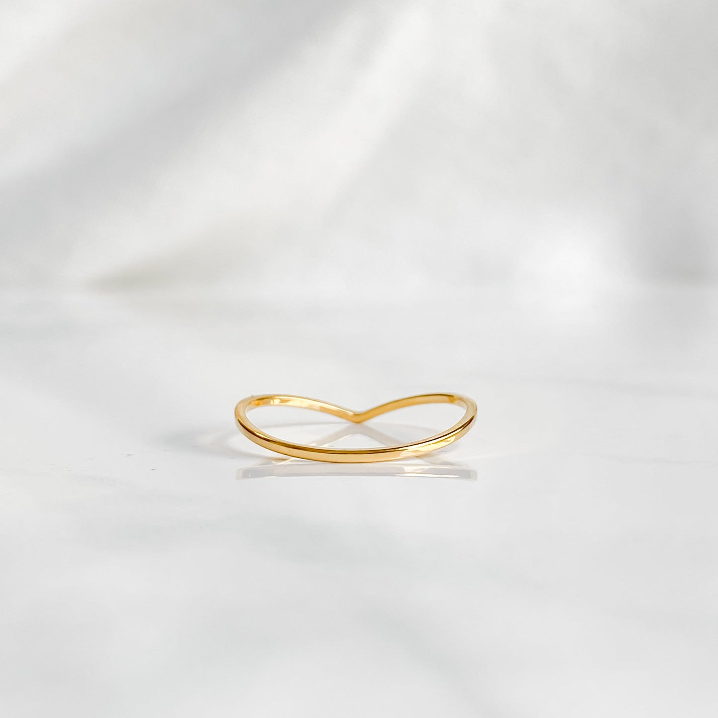 Bague fine dorée Bellona en forme de V photographiée vue du dessus.