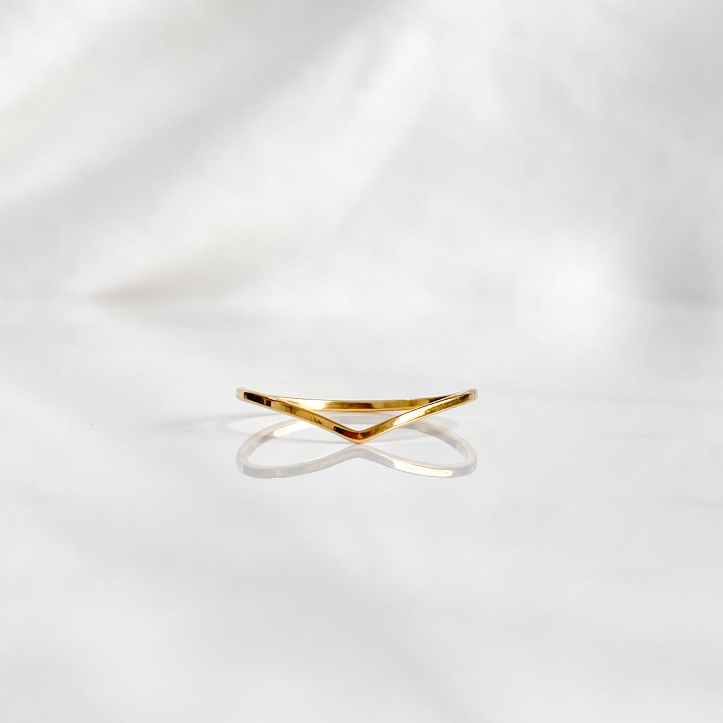 Bague minimaliste dorée Bellona en acier inoxydable 18K vue de face sur fond blanc.