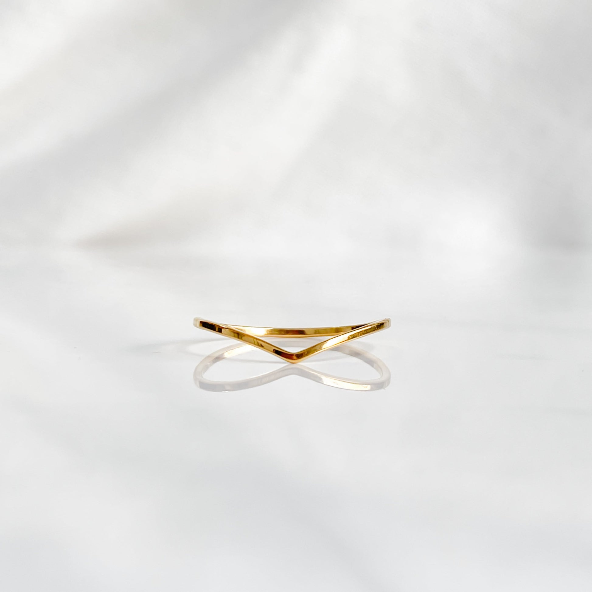 Bague minimaliste dorée Bellona en acier inoxydable 18K vue de face sur fond blanc.