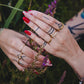 Bague ondulée dorée Naïa photographiée en extérieur au milieu des fleurs