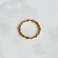Bague Rhéa torsadée en acier inoxydable plaqué or 18K, vue du dessus sur fond blanc.