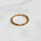 Bague Rhéa fine et minimaliste en acier inoxydable plaqué or 18K, vue inclinée sur fond blanc.