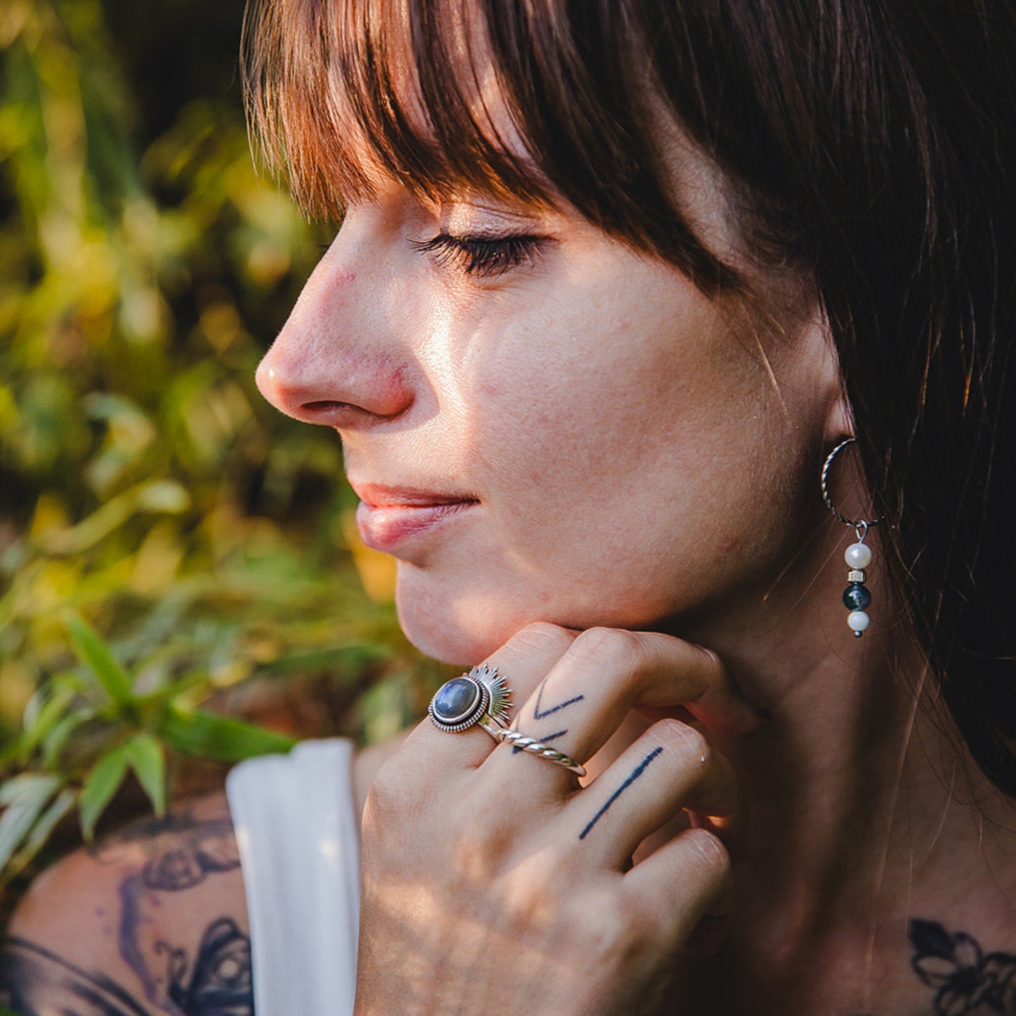 Femme portant la bague torsadée Sylva en argent 925 au doigt, style naturel, collection Jardin Secret.