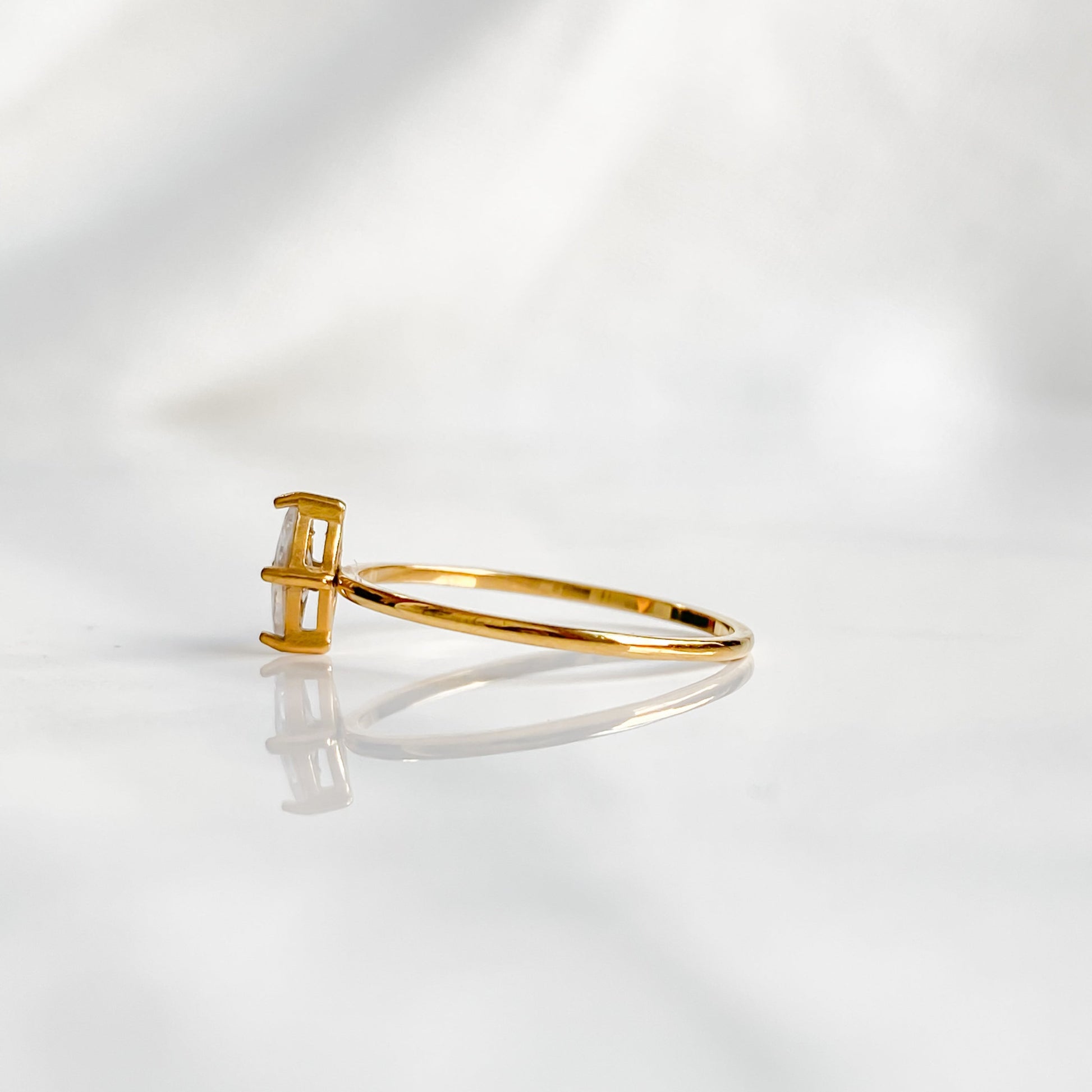 Bague dorée Venus photographiée de côté, mettant en valeur le zircon serti et l’anneau jaune raffiné.