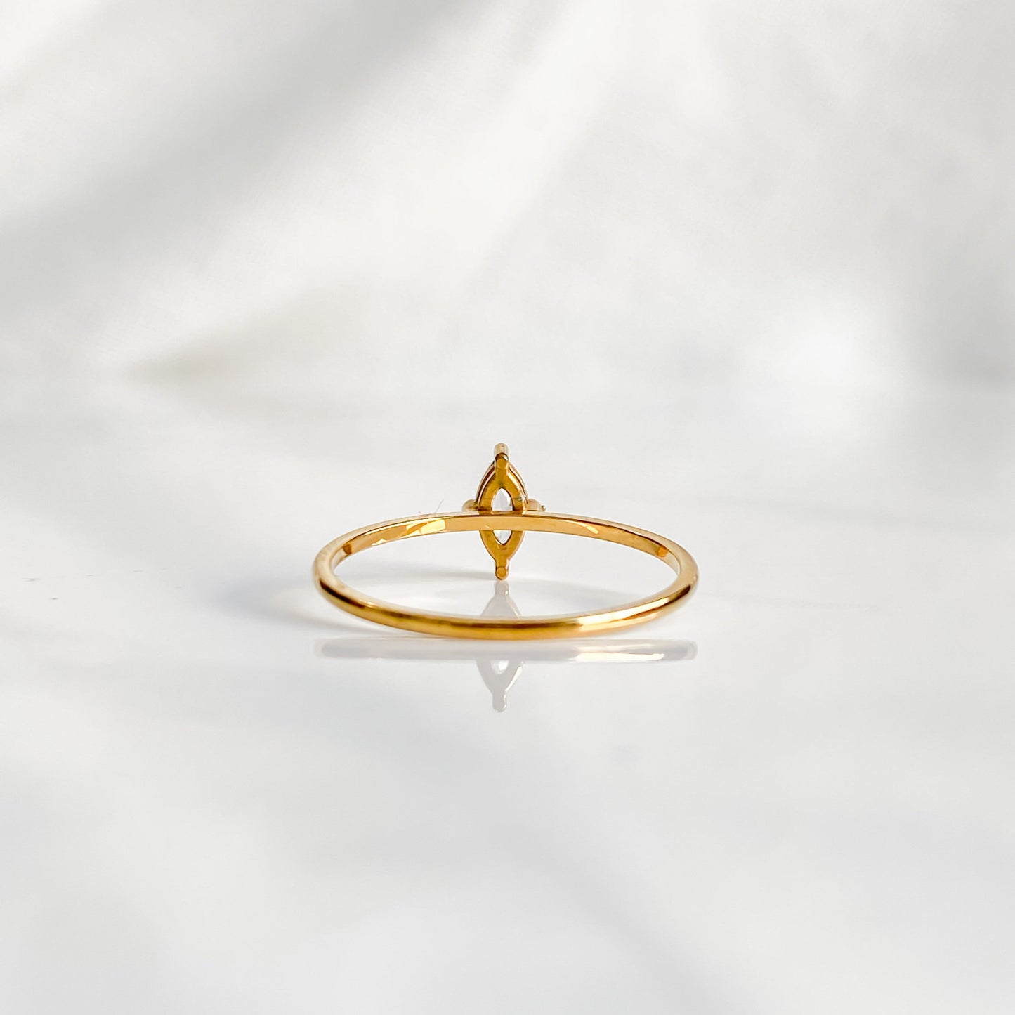 Vue de face de la bague solitaire Venus, zircon blanc taille marquise serti sur anneau doré minimaliste.