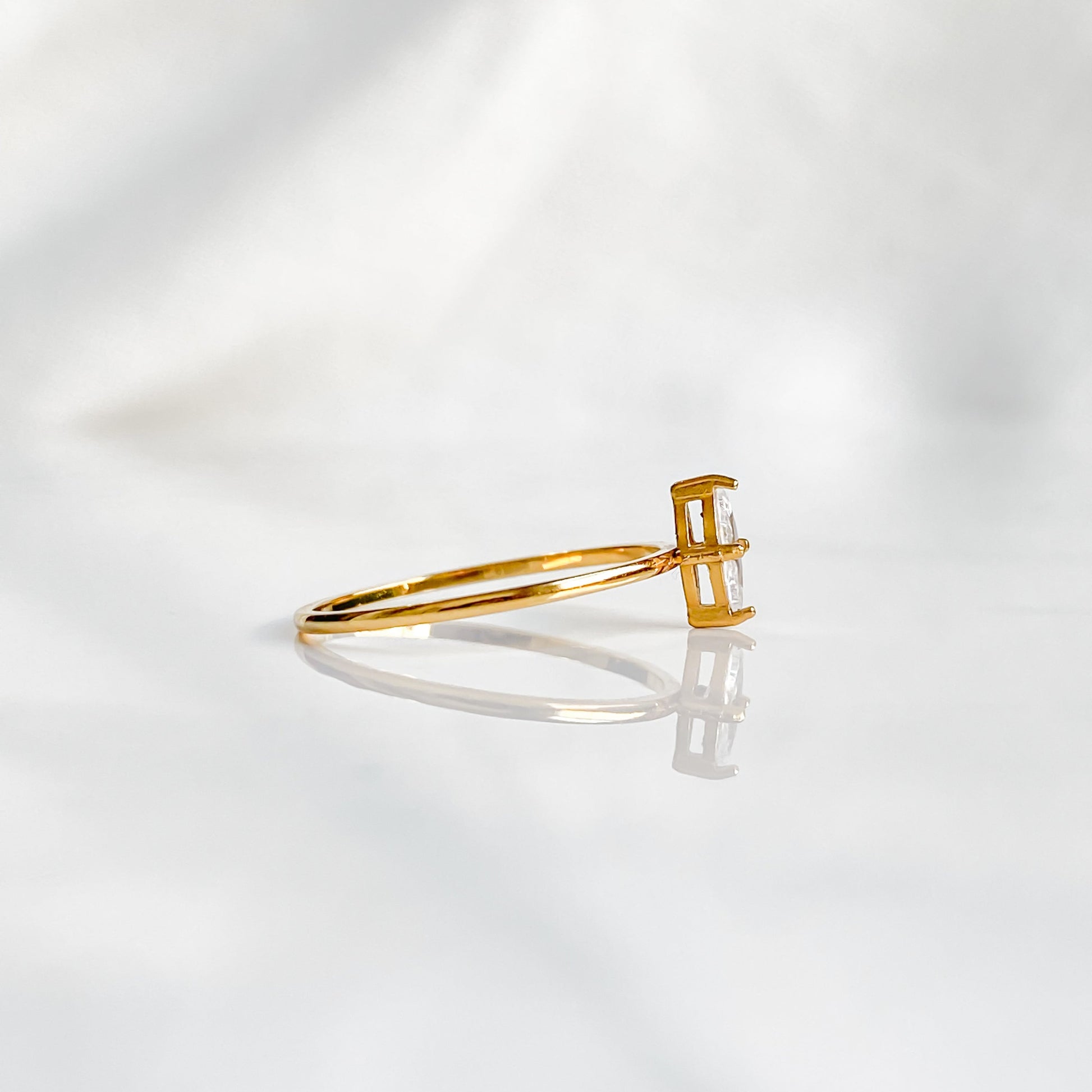 Bague solitaire dorée Venus vue de profil, zircon marquise sur anneau fin en acier inoxydable 18K.