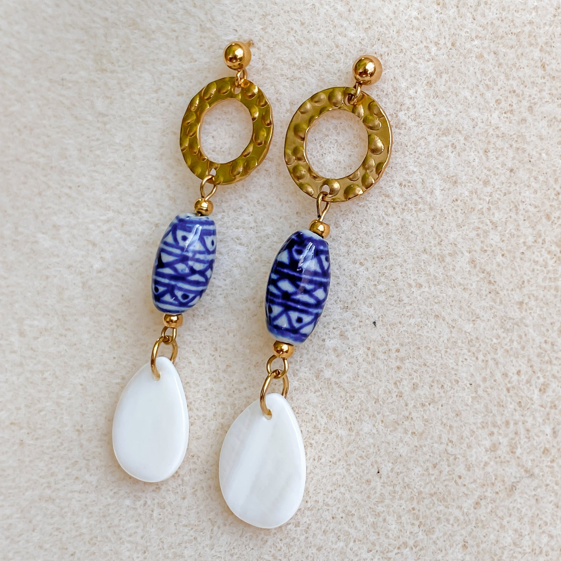 Paire complète des boucles d’oreilles Abalone faites main à Montréal, avec cercle doré, céramique bleue et nacre naturelle.
