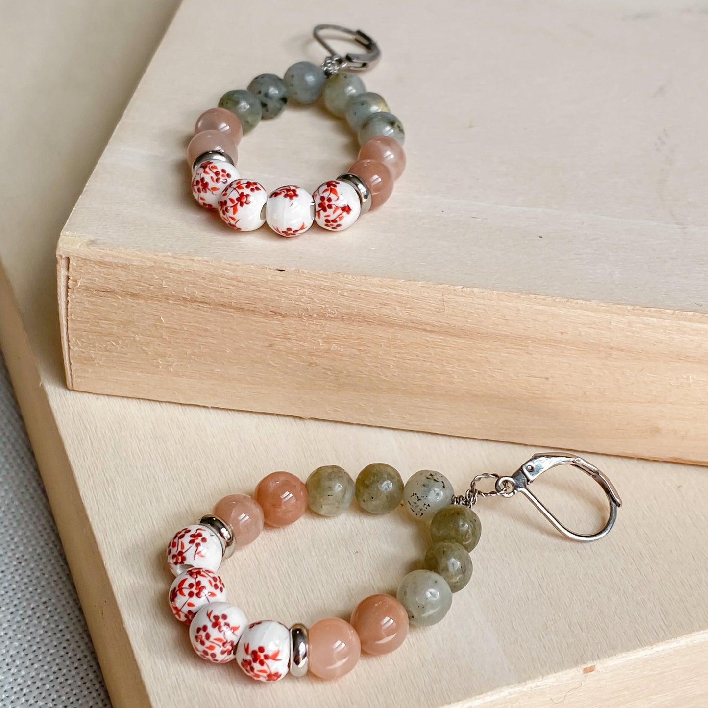Paire de boucles d’oreilles bohème chic Capri en labradorite, pierre de soleil et céramique fleurie artisanale.