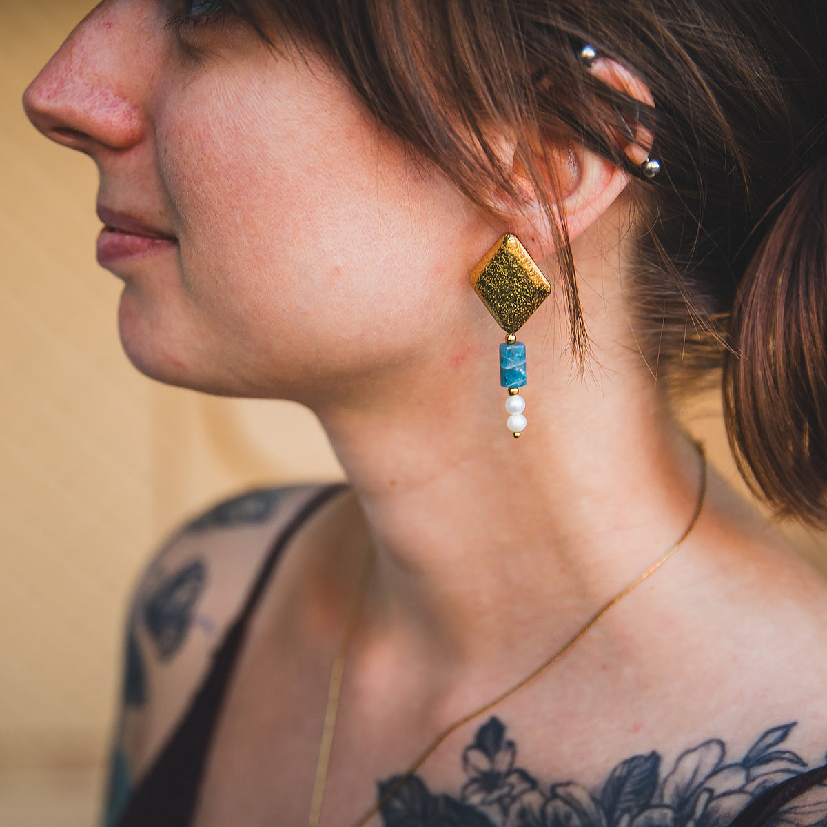 Boucle d’oreille Chaouen dorée portée de profil avec apatite bleue et perles d’eau douce