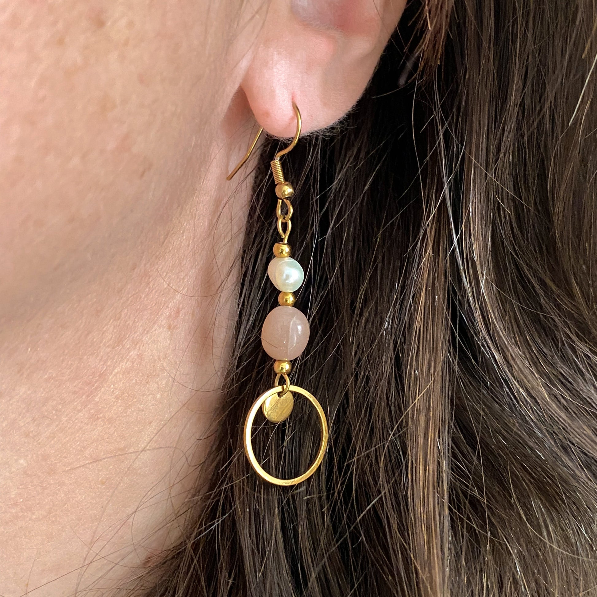Boucles d’oreilles pendantes Daphné en plaqué or avec perles d’eau douce et pierre de soleil, portées à l’oreille vue de profil