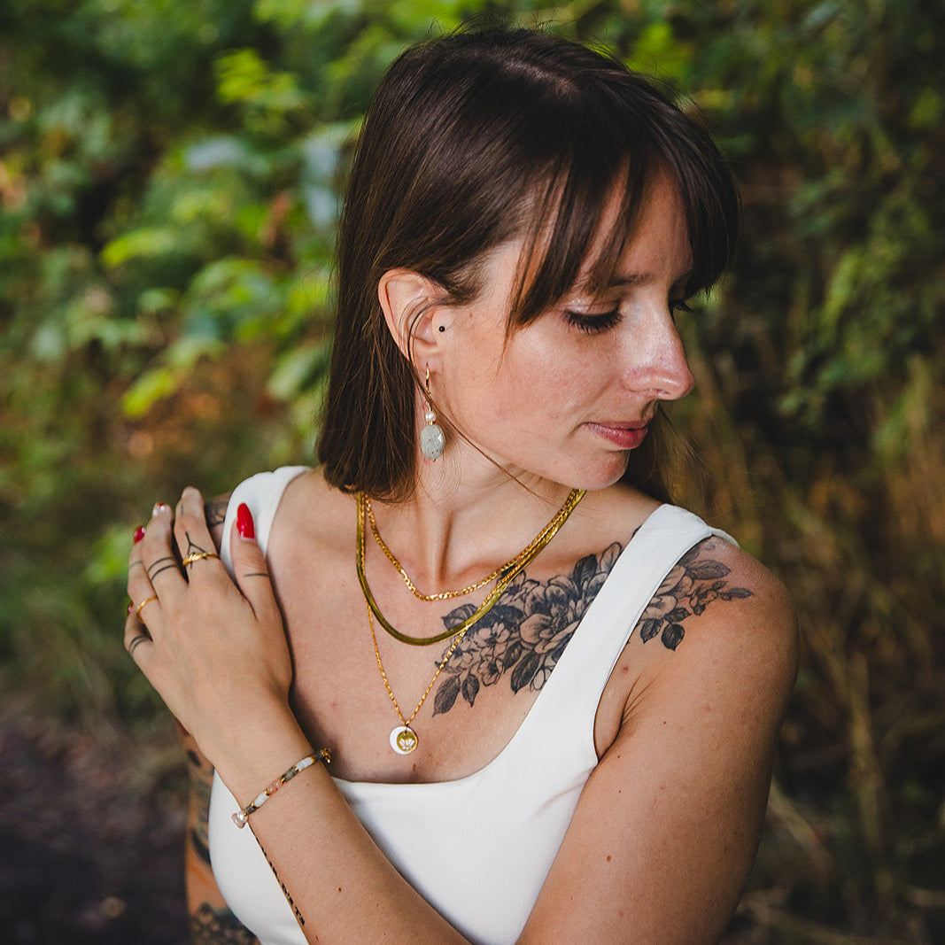 Modèle portant les boucles Athéna avec labradorite, bijou artisanal collection Jardin Secret.