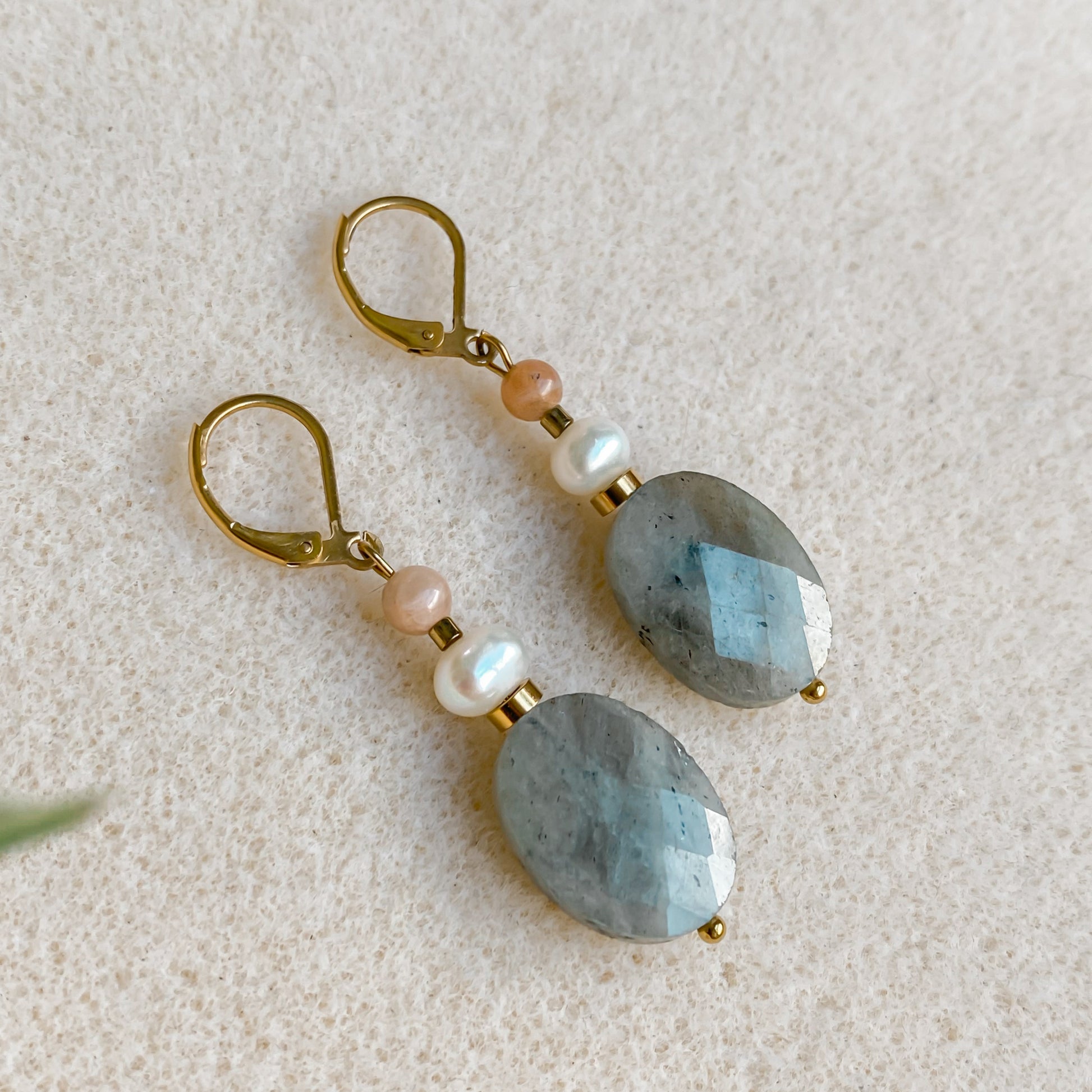 Vue rapprochée des boucles d’oreilles Athéna en labradorite facettée et perle naturelle.