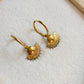 Détail du motif solaire des boucles d’oreilles Midi dorées