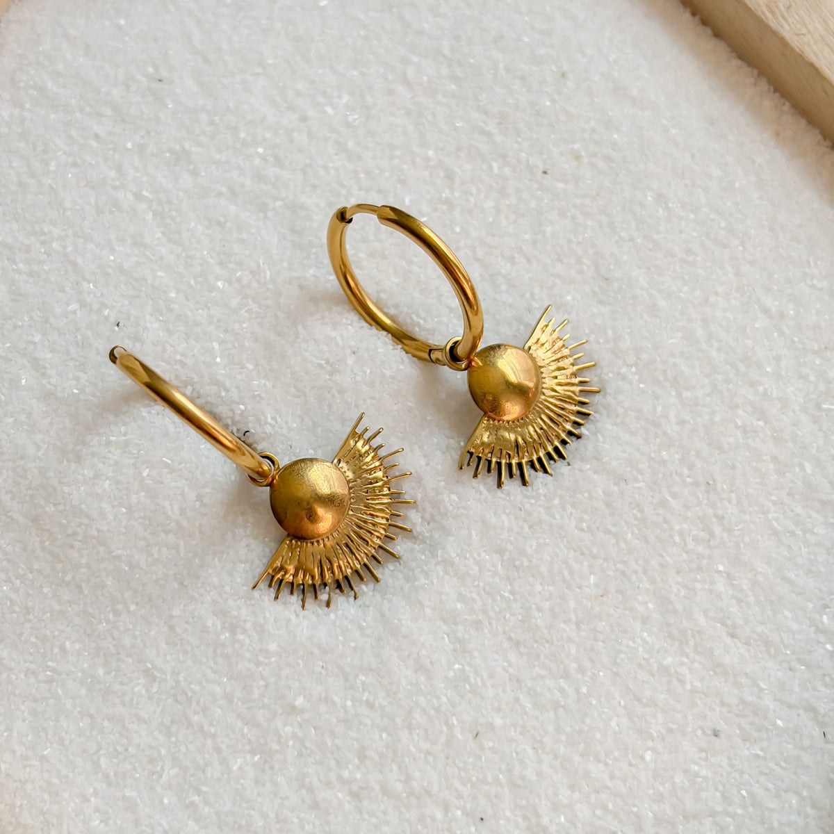Détail du motif solaire des boucles d’oreilles Midi dorées