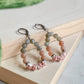 Boucles d’oreilles pendantes Capri en pierres naturelles labradorite et pierre de soleil avec perles en céramique fleurie – fait main à Montréal.