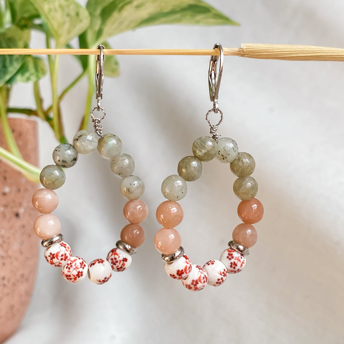 Boucles d’oreilles Capri en pierres naturelles pendantes, montées à la main à Montréal, suspendues sur support décoratif.