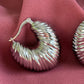 Détail de la texture ondulée des boucles d’oreilles Sirocco argentées